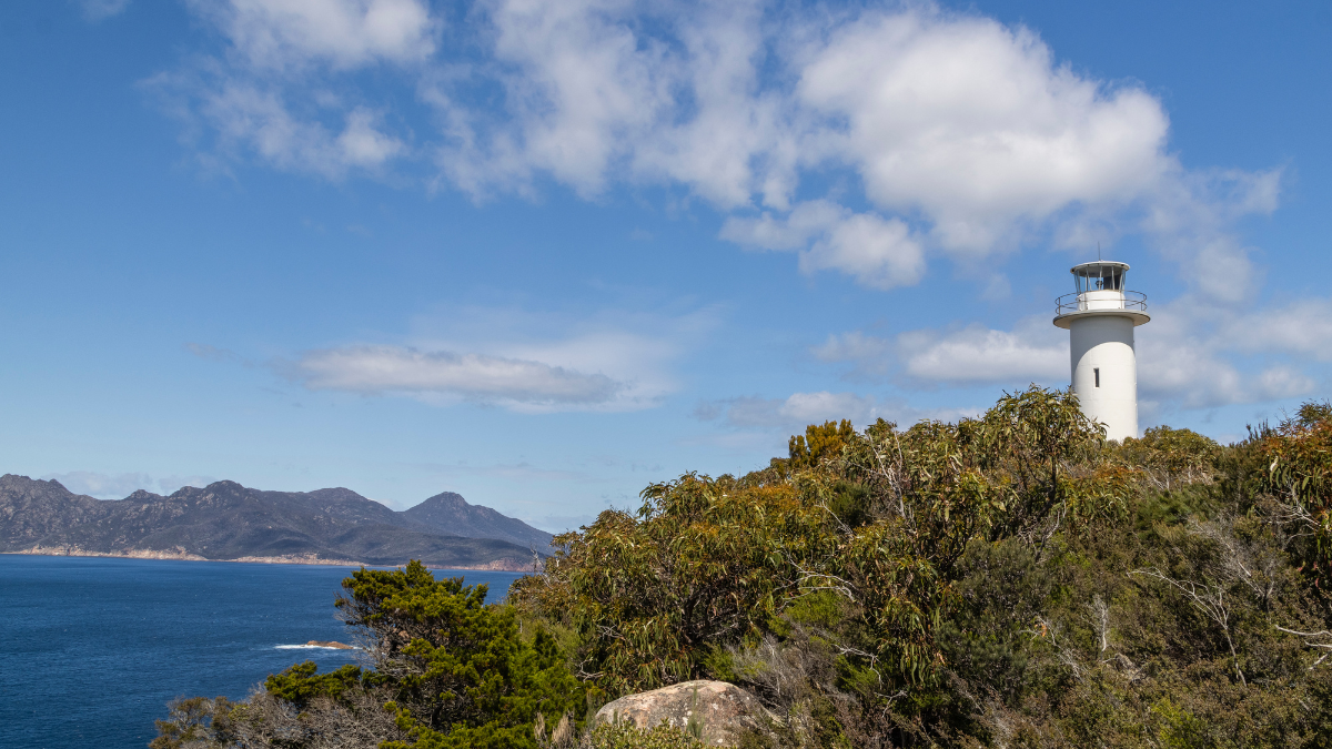 lighthouse on a mountain next to the water