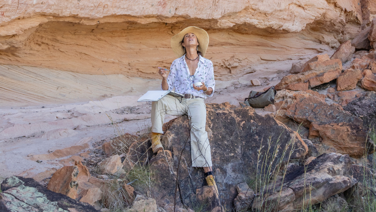 Woman Sitting on Rock with art book